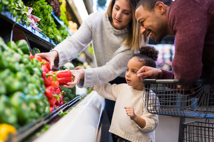 Mixed race couple grocery shopping with their preschool-age daughter Mixed race couple grocery shopping with their preschool-age daughter