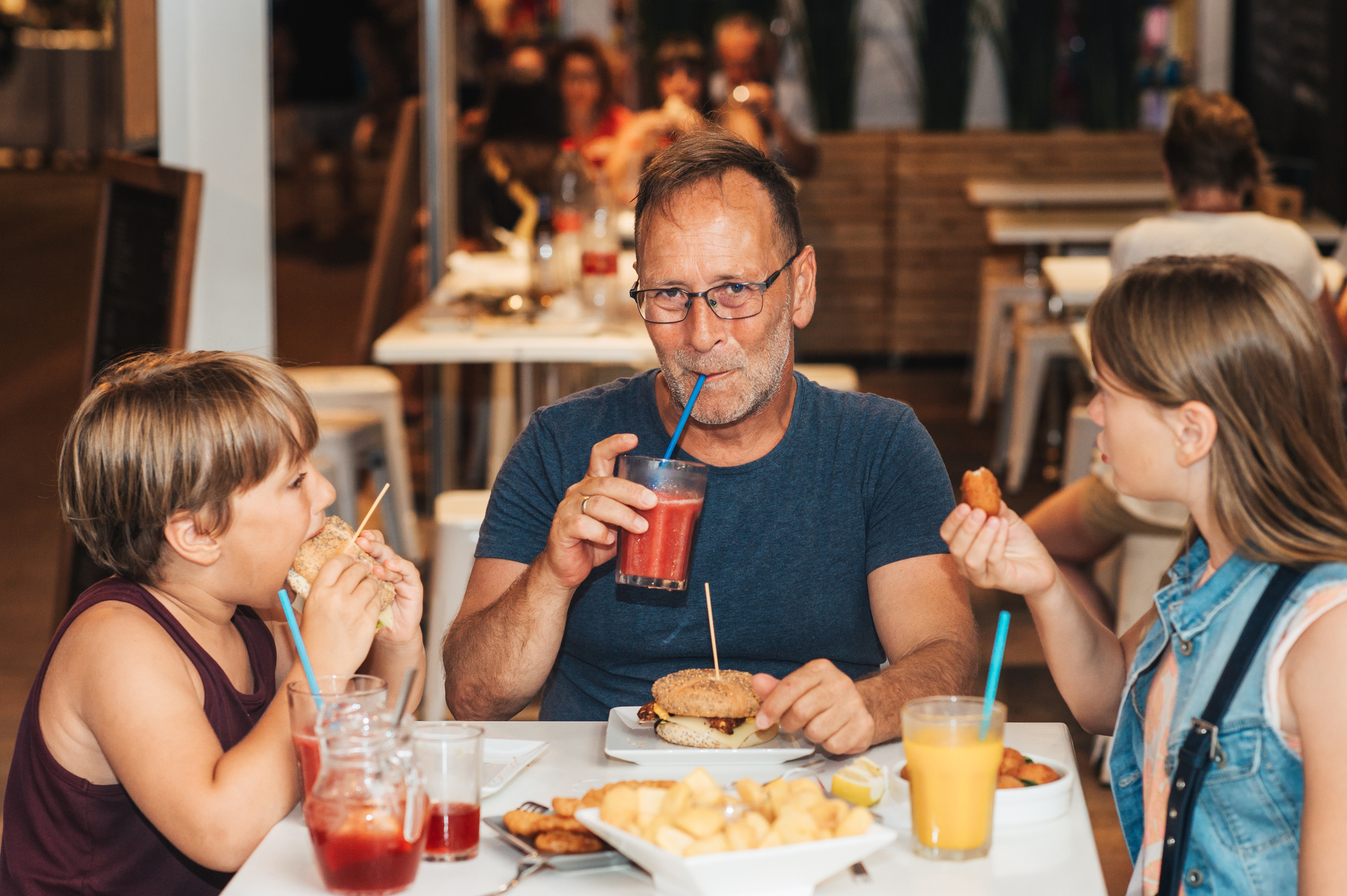Happy family with children in outdoor restaurant during summer vacation in Spain Happy family with children in outdoor restaurant during summer vacation in Spain
