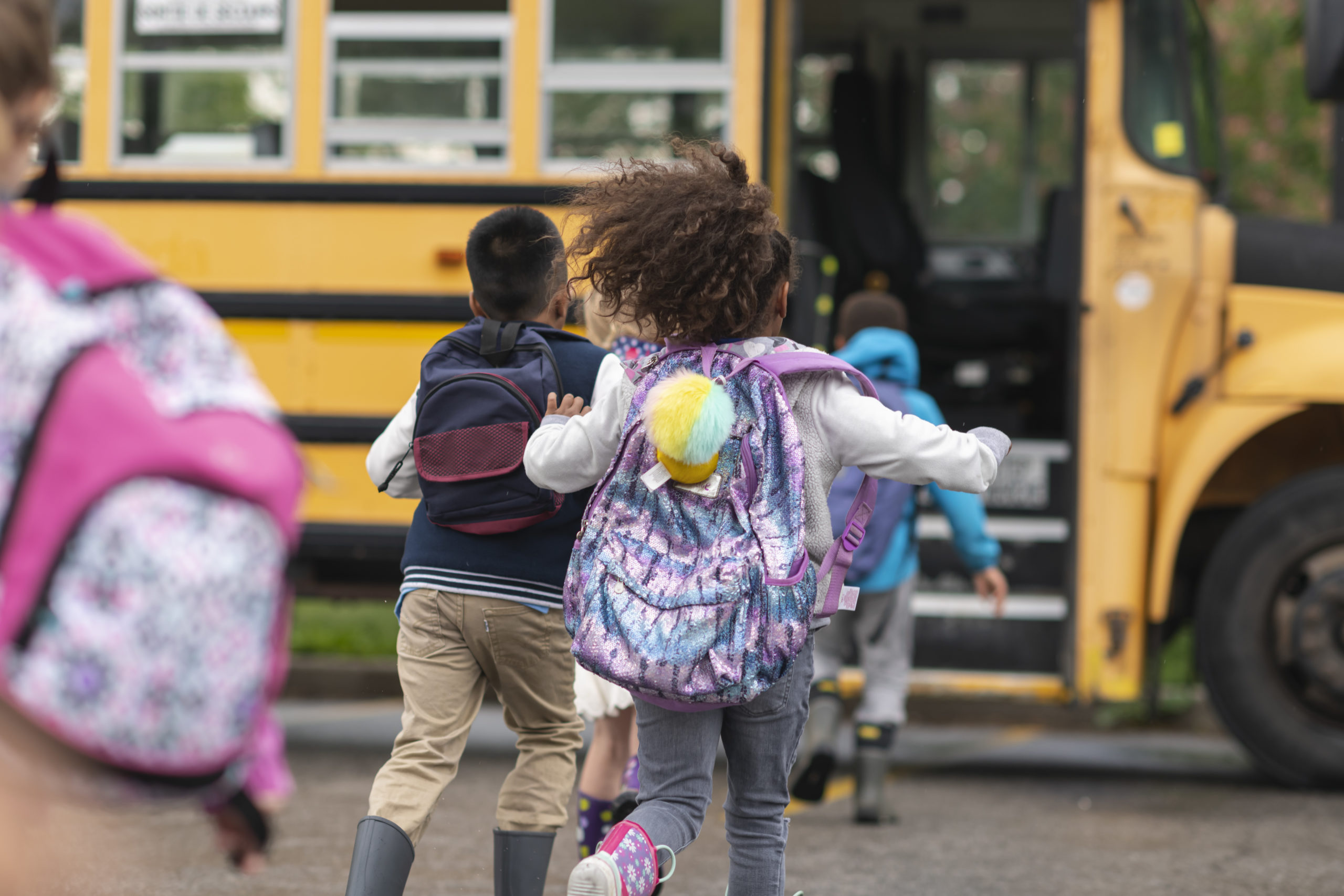 Diverse group of happy children getting on school bus Diverse group of happy children getting on school bus