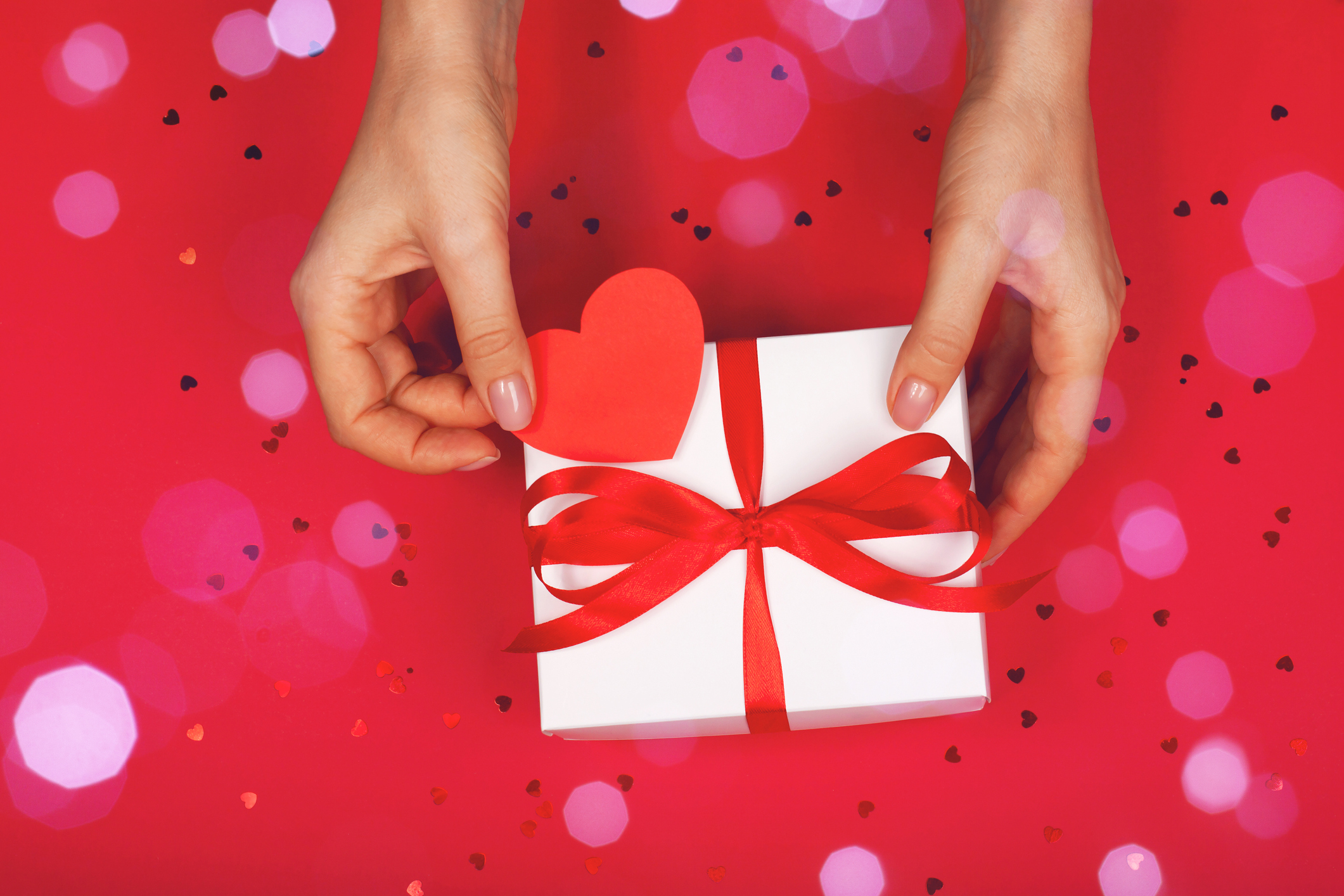 Beautiful female hand with packaged cute gift Beautiful female hand with packaged cute gift