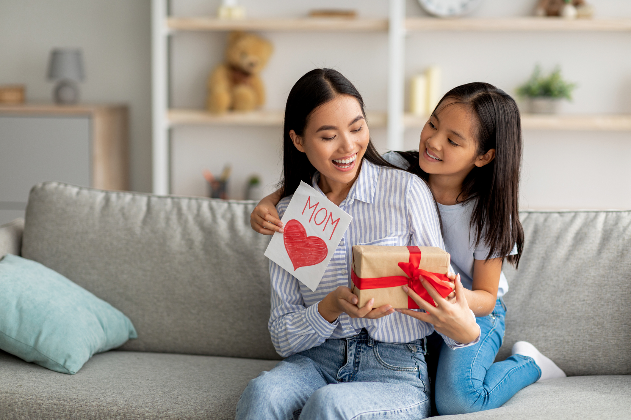 Congratulations. Loving asian daughter greeting surprised mom with Mother’s Day, giving her handmade card and gift box Congratulations. Loving asian daughter greeting surprised mom with Mother's Day, giving her handmade card and gift box