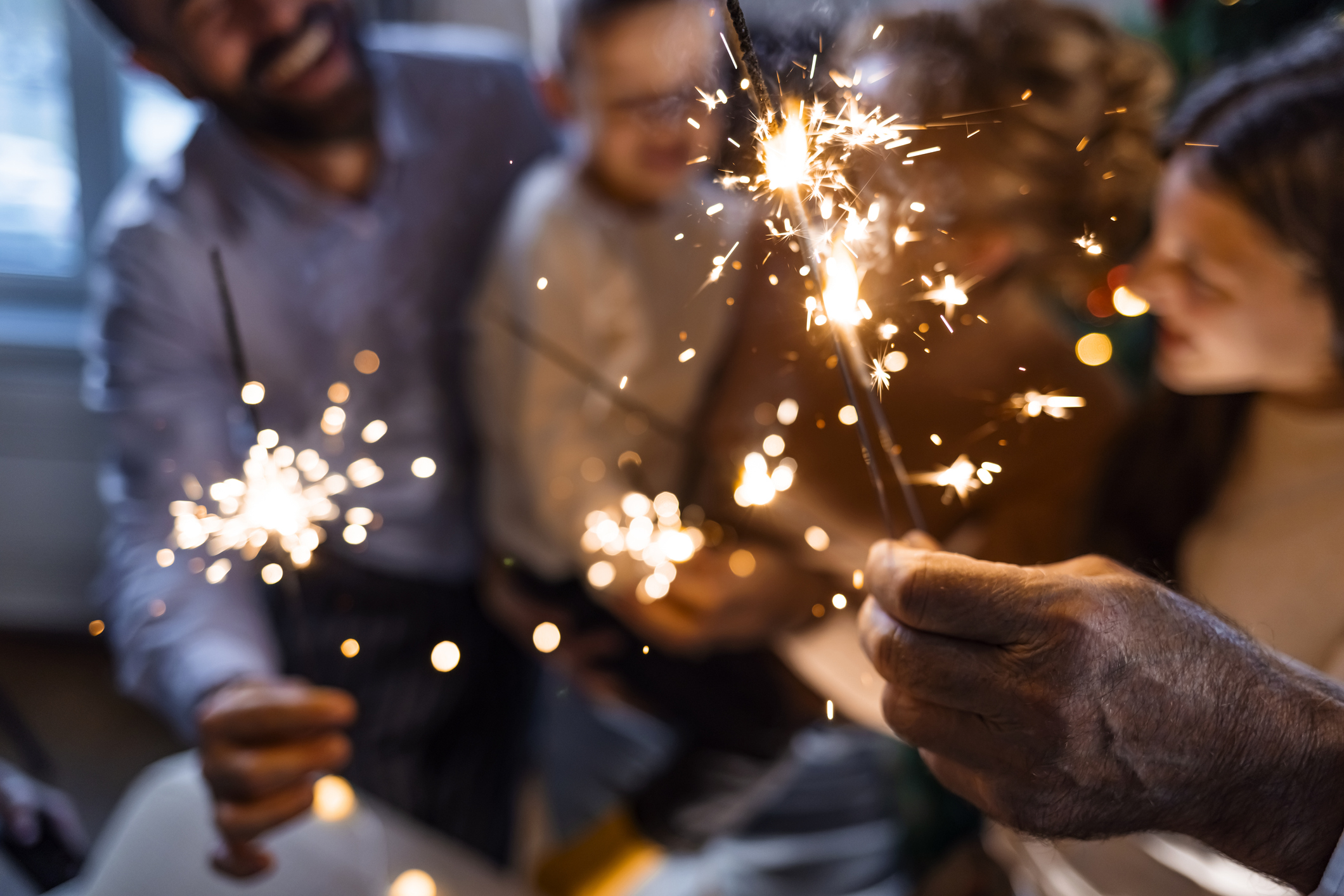 Family in living room during Christmas holidays, holding sprinklers